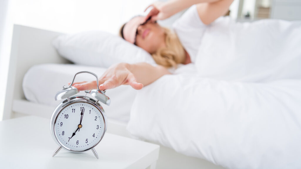 femme dans un lit propre blanc qui se réveille